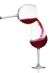 Red wine splash in the glass, pouring from a wineglass isolated