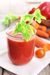 Glass of tomato juice with vegetables on wooden table close up