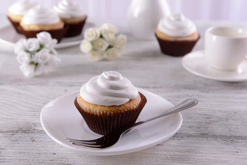 Delicious cupcakes on table on light background