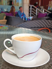 Cup of coffee in the cafeteria and  young couple