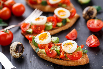 Bruschetta with tomato, avocado and quail egg