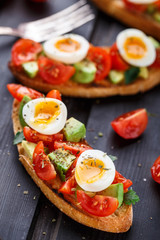 Bruschetta with tomato, avocado and quail egg