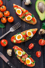 Bruschetta with tomato, avocado and quail egg