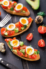 Bruschetta with tomato, avocado and quail egg