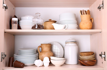 Kitchen utensils and tableware on wooden shelves