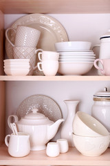 Obraz na płótnie Canvas Kitchen utensils and tableware on wooden shelves