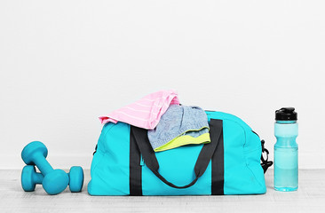 Sports bag with sports equipment in room