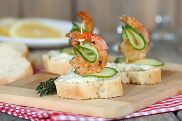 Appetizer canape with shrimp and cucumber on table close up