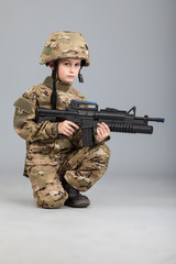 Young boy dressed like a soldier with rifle