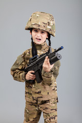 Fototapeta premium Young boy dressed like a soldier with rifle