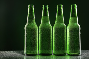 Glass bottles of beer on dark background