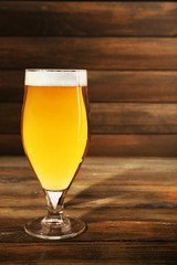 Glass of beer on wooden background