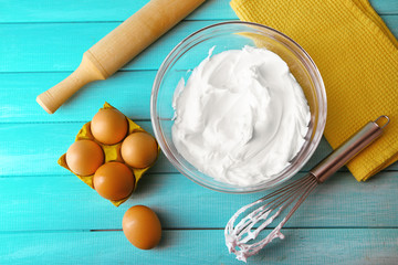 Whipped egg whites for cream on wooden table, top view