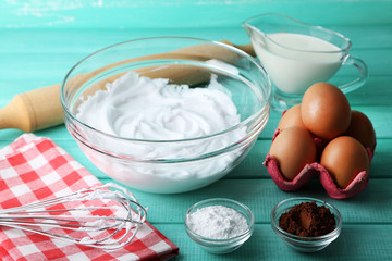 Whipped egg whites for cream on color wooden background