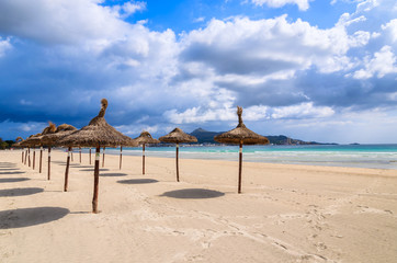 Umbrellas on sandy Alcudia beach, Majorca island, Spain