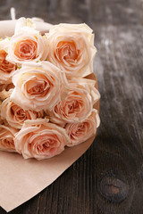 Bouquet of beautiful fresh roses wrapped in paper