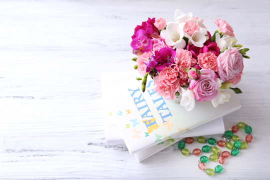 Beautiful fresh spring flowers with stack of books, top view