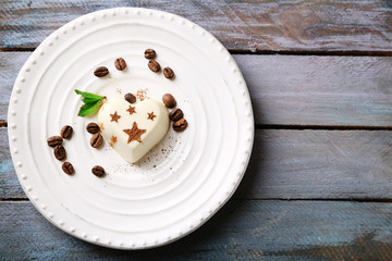 Tasty panna cotta dessert on plate, on wooden table
