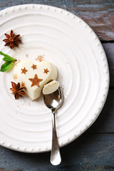 Tasty panna cotta dessert on plate, on wooden table