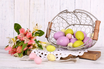 Easter composition with Easter eggs in basket and flowers,
