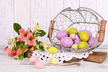 Easter composition with Easter eggs in basket and flowers,