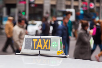 Taxischild mit Menschen im unscharfen Hintergrund