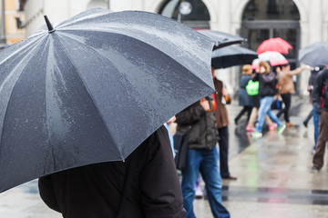 Menschen mit Regenschirmen in der Stadt