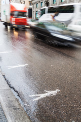 städtischer Verkehr auf nasser Straße in Bewegungsunschärfe