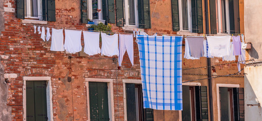 Naklejka premium Venetian windows with the laundry drying on a wire