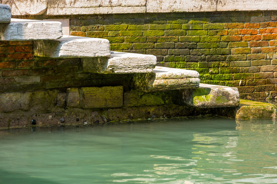 Fototapeta Closeup on staircase in narrow canal in center of Venice.