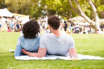 Rear View Of Couple Relaxing At Outdoor Summer Event