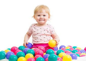 Fototapeta na wymiar Little girl in ball pit woth colored balls