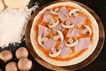 pizza and ingredients for pizza on the wooden background