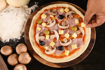 pizza and ingredients for pizza on the wooden background