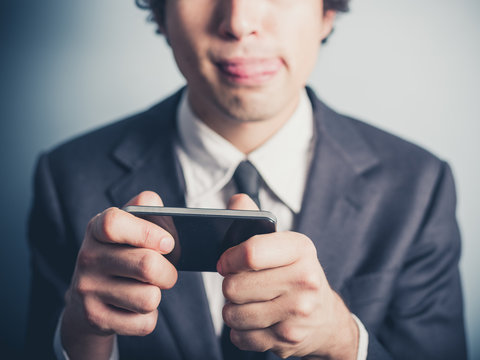 Businessman playing games on his smartphone