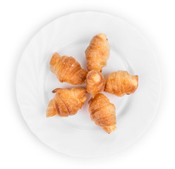 Fresh croissants on white plate.