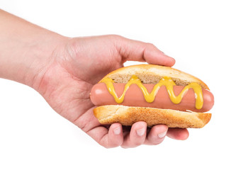 Hand holding hot dog with mustard.