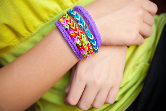 Child hands with Colorful rubber rainbow loom band bracelet