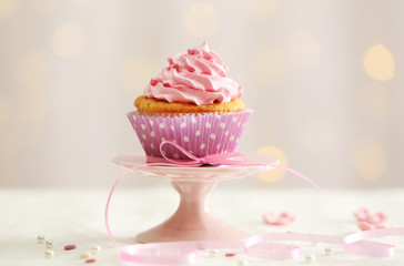 Sweet cupcake on table on light background