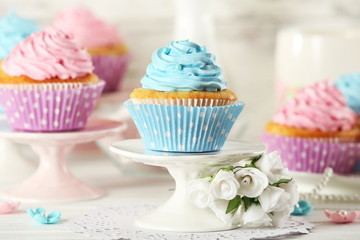 Delicious cupcakes on table on light background