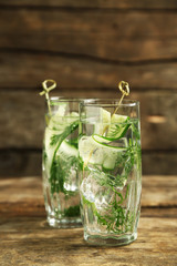Glasses with fresh organic cucumber water on wooden table
