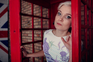 Tourist in a typical red telephone box in London