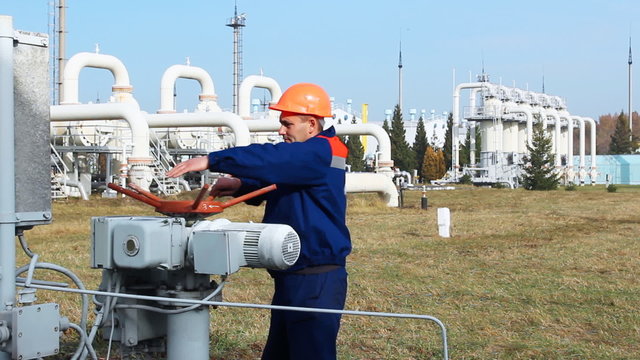 worker closes recirculation valve on gas compressor station