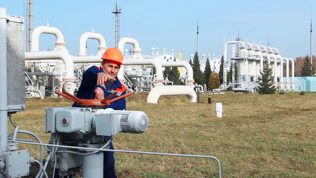 worker opens recirculation valve on gas compressor station