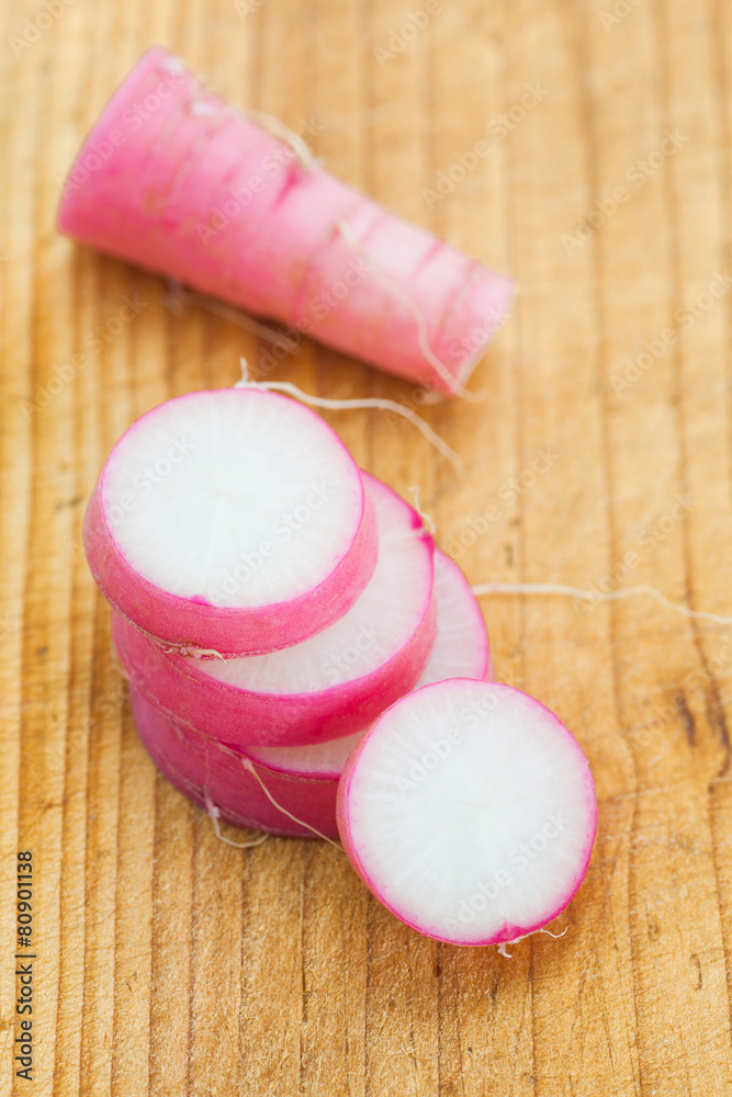 Wall mural fresh purple daikon radish slice on brown wood background.