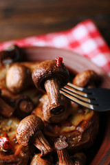 Baked potatoes with mushrooms in bowl on table close up