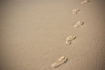 Fototapeta na wymiar Human footprints on beach sand