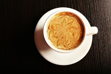 Cup of latte on wooden table, top view