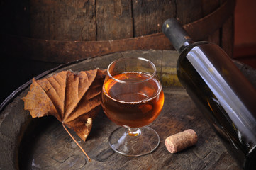 Glass of cognac on the vintage wooden barrel