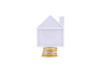 The house stands on a few coins on a white background